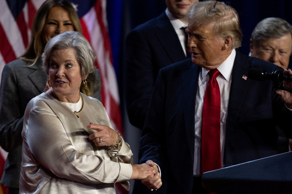 Republican presidential nominee and former U.S. President Donald Trump shakes hands with his senior advisor Susie Wiles as he speaks, following early results from the 2024 U.S. presidential election in Palm Beach County Convention Center, in West Palm Beach, Florida, U.S., November 6, 2024.