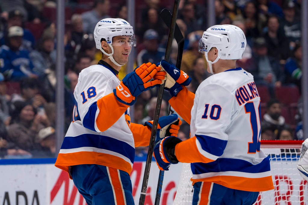 New York Islanders forward Pierre Engvall (18) and forward Simon Holmstrom (10) celebrate Engvall's goal against the Vancouver Canucks during the second period at Rogers Arena.