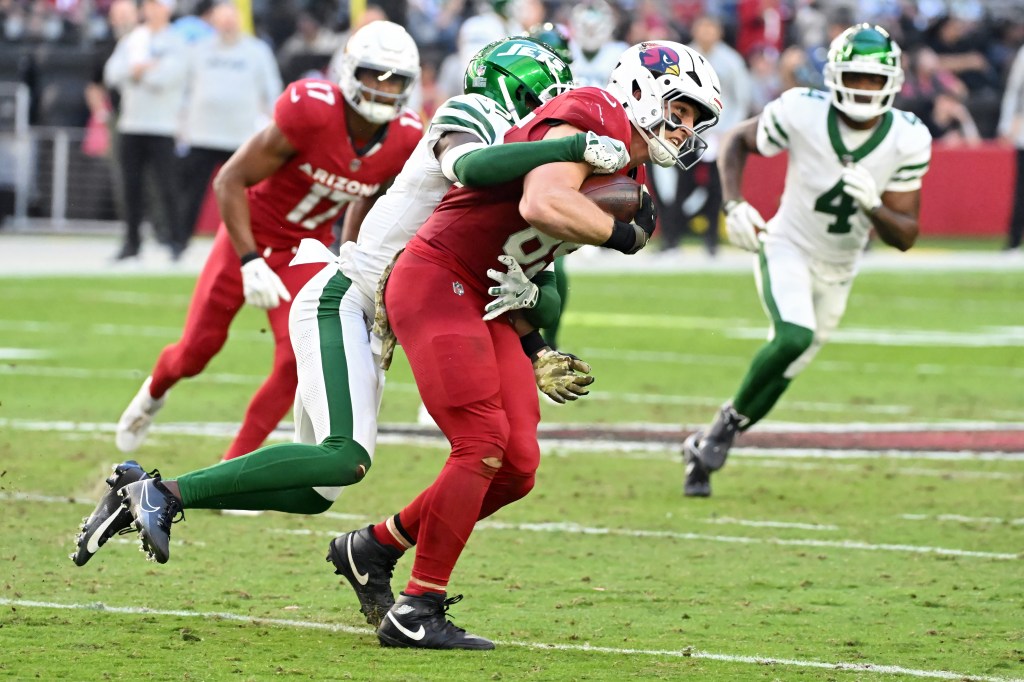 Trey McBride #85 of the Arizona Cardinals runs with the ball while being tackled by Sauce Gardner #1 of the New York Jets in the second quarter at State Farm Stadium on November 10, 2024 in Glendale, Arizona. 