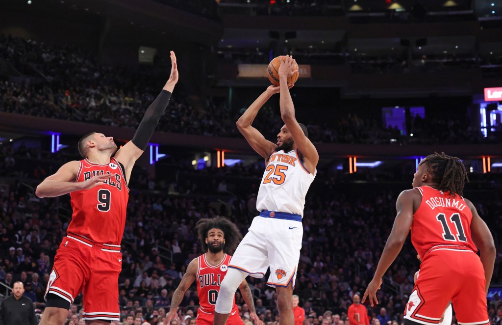 New York Knicks forward Mikal Bridges #25 puts up a shot as Chicago Bulls center Nikola Vucevic #9 jumps to defend during the fourth quarter.