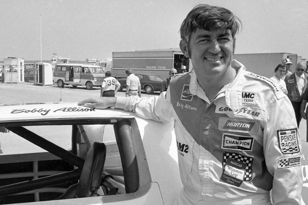 Bobby Allison stands beside his car and talks with the press after winning the pole position during qualifyiing for the 500 mile grand national stock car race at Pocono Raceway, Aug. 2, 1975, in Long Pond, Pa.