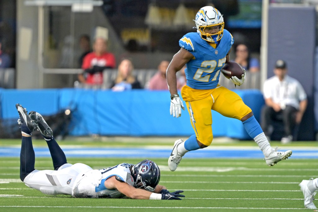 Los Angeles Chargers running back J.K. Dobbins (27) gets past Tennessee Titans linebacker Jack Gibbens (50) in the first half at SoFi Stadium.