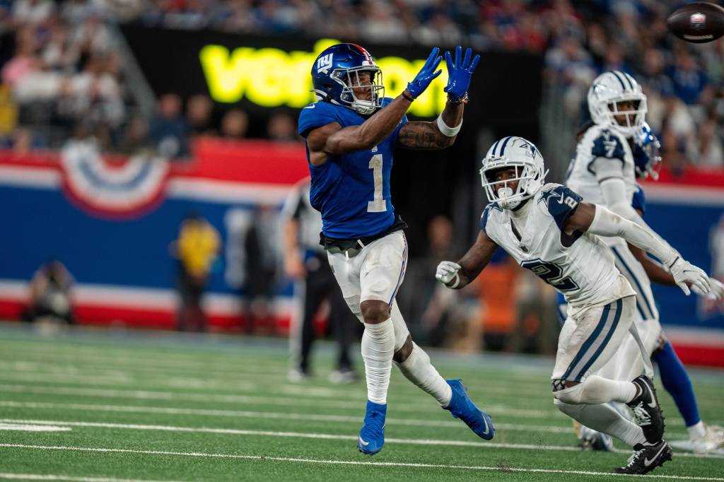 New York Giants wide receiver Malik Nabers (1) catches a pass in the fourth quarter before being tackled by Dallas Cowboys cornerback Jourdan Lewis (2) at MetLife Stadium. 