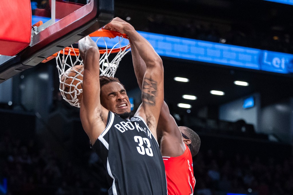 Nic Claxton slams home a reverse dunk around Jalen Smith during the Nets' win over the Bulls.