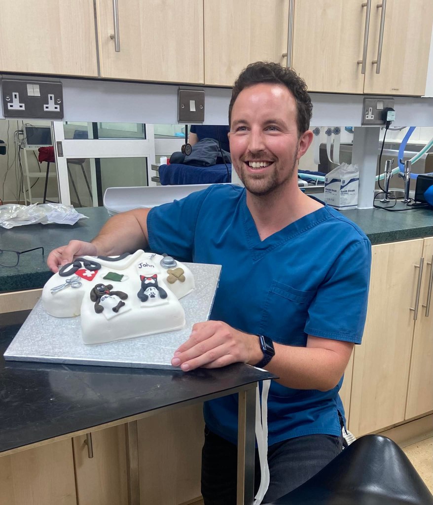 Dr john ellis smiling with a cake