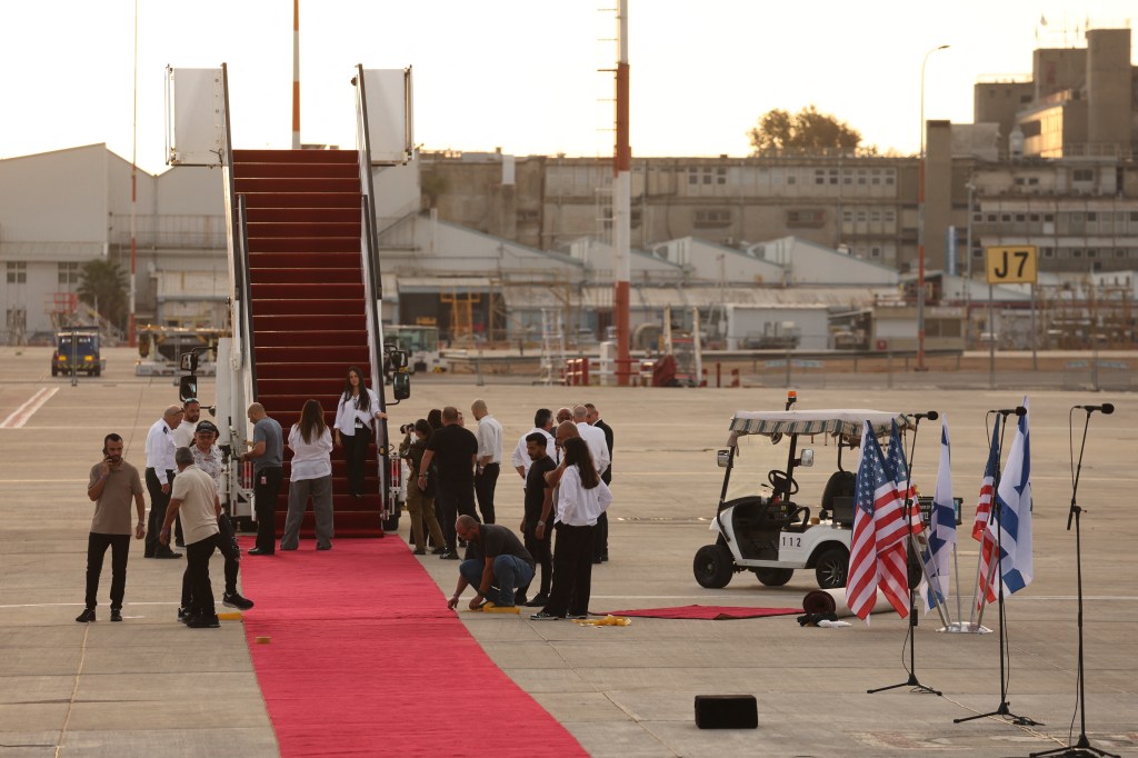 Israeli airport staff prepare the Red Carpet ahead of US President Donald Trump's arrival at Ben Gurion Airport on the outskirts of Lod near Tel Aviv on October 13, 2025. 