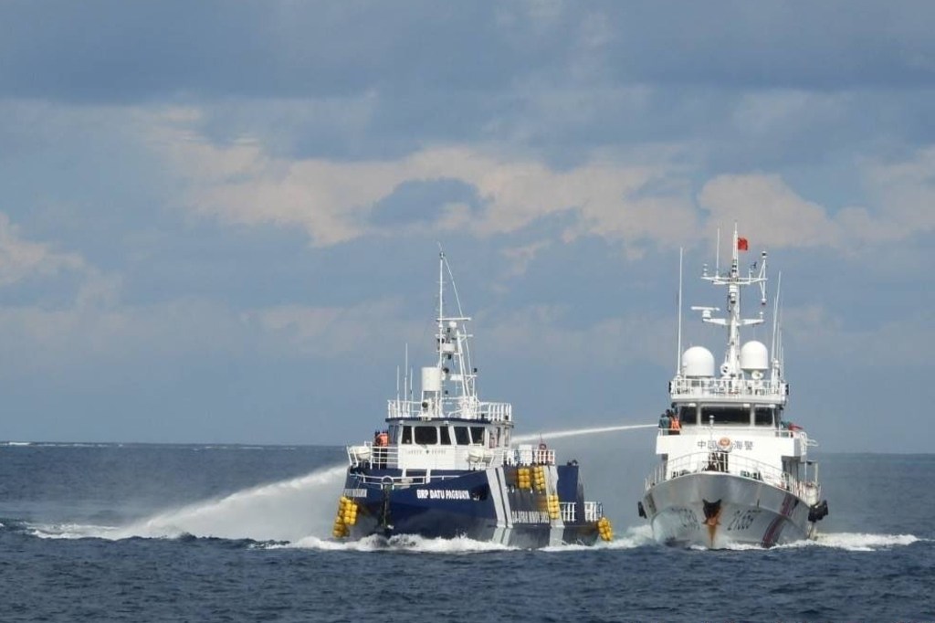 A Chinese Coast Guard vessel fires its water cannon at the Philippine's BRP Datu Pagbuaya near Thitu island locally called Pag-asa island at the South China Sea on Oct. 12, 2025.