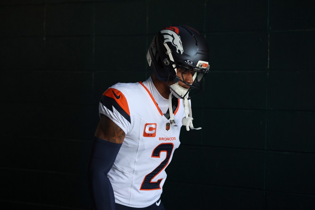 Denver Broncos player Pat Surtain II in uniform, looking down.