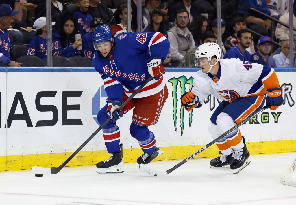 New York Rangers center Noah Laba skates with the puck past New York Islanders left wing Alex Jefferies.