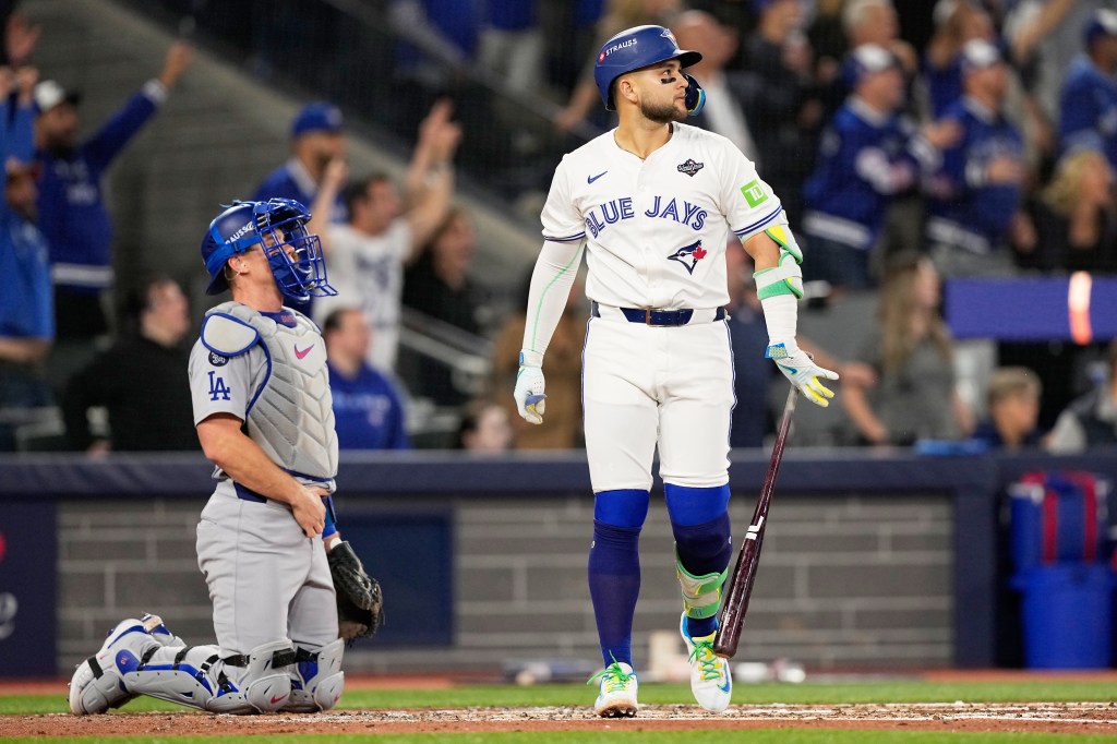 Toronto Blue Jays' Bo Bichette watches his three-run home run against the Los Angeles Dodgers as the Dodgers catcher kneels during Game 7 of baseball's World Series.