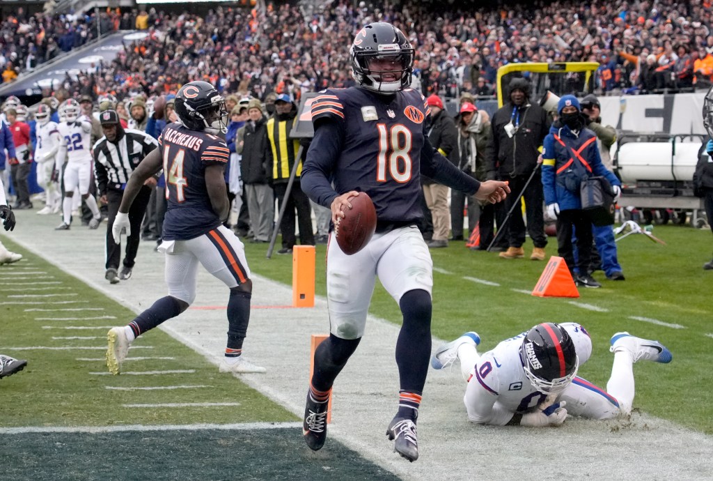 Chicago Bears quarterback Caleb Williams (18) scores a touchdown against New York Giants linebacker Brian Burns (0).