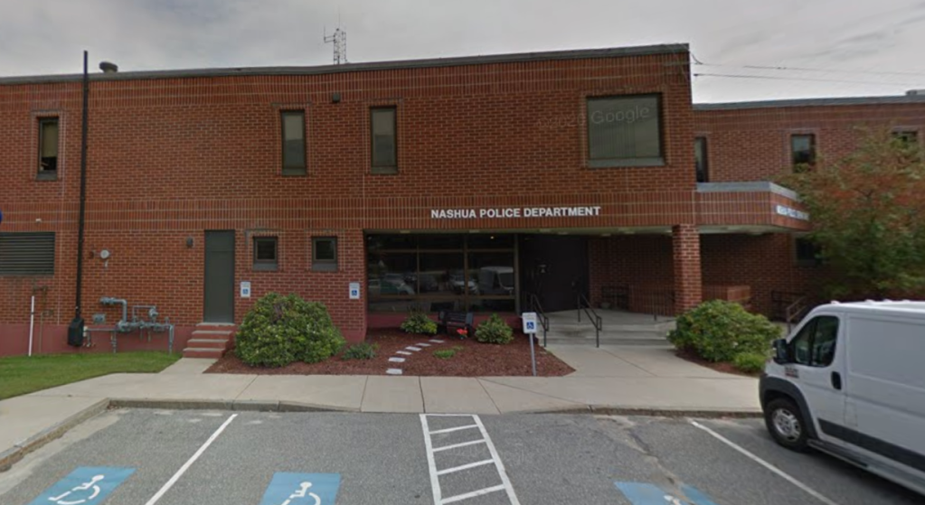 The Nashua Police Department building, a brick structure with the department's name displayed prominently.