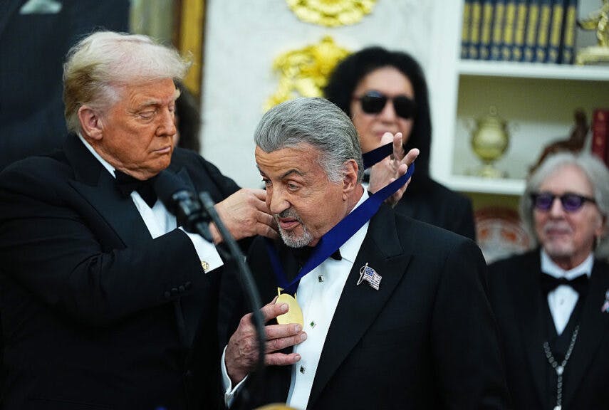 WASHINGTON, DC - DECEMBER 06: U.S. President Donald Trump (L) presents actor Sylvester Stallone (R) a medal for the 2025 Kennedy Center Honorees during a medal presentation in the Oval Office of the White House on December 06, 2025 in Washington, DC. The 2025 Kennedy Center honorees are Sylvester Stallone, George Strait, the rock band KISS, Gloria Gaynor, and Michael Crawford. (Photo by Aaron Schwartz/Getty Images)