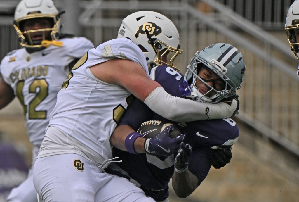 Colorado's #98 Alexander McPherson tackling Kansas State's #6 Qua Moss in a football game.