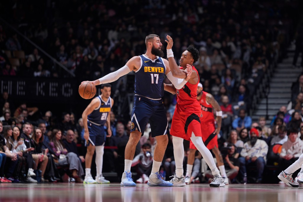Denver Nuggets' Jonas Valanciunas with the ball, defended by a Toronto Raptors player.