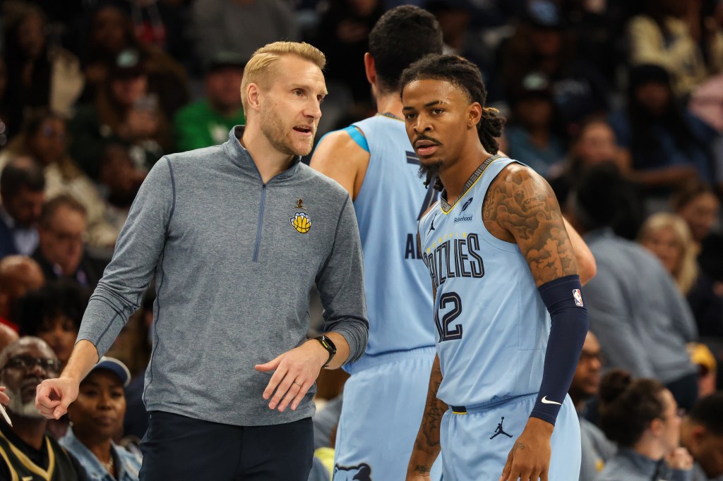 Memphis Grizzlies head coach Tuomas Iisalo talking to Ja Morant during a basketball game.