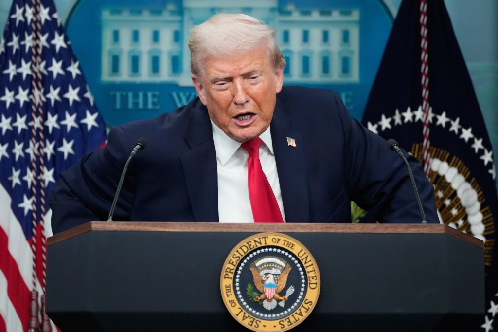 President Donald Trump listens to a reporter's question during a White House press briefing.