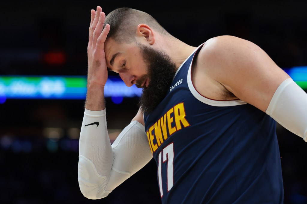 Denver Nuggets center Jonas Valanciunas covering his forehead with his hand.