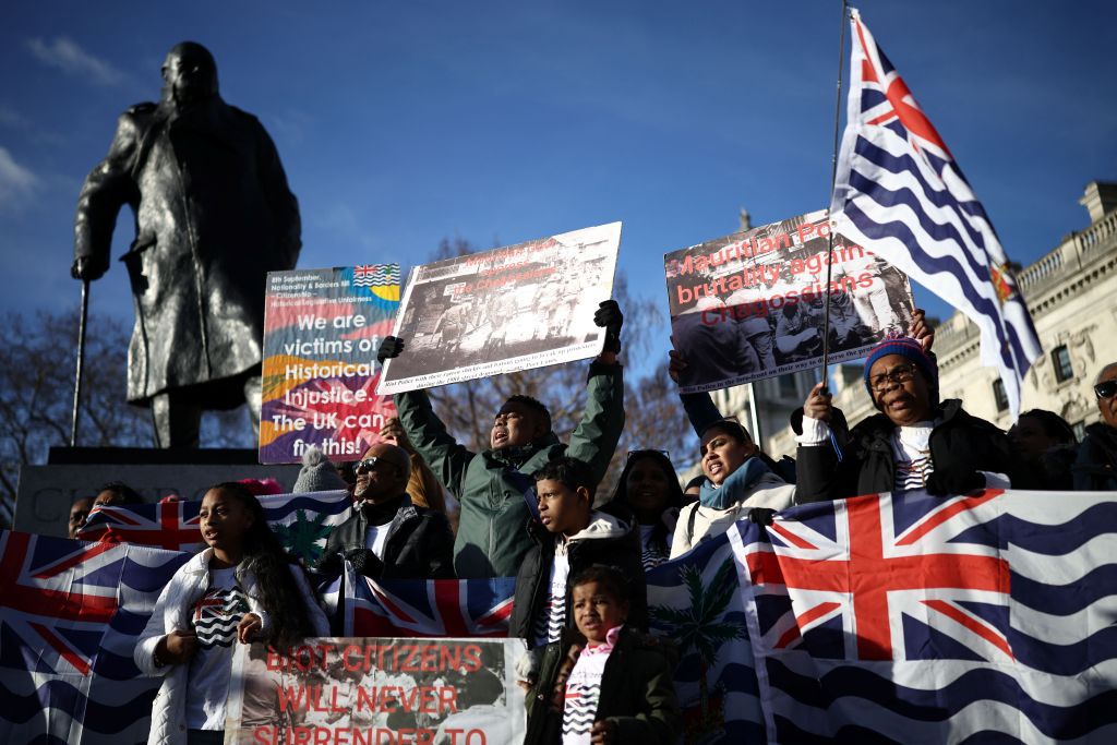 Supporters and members of the British Indian Ocean territory Chagos Archipelago hold placards and the territory's flag outside the Houses of Parliament in London on January 7, 2026
