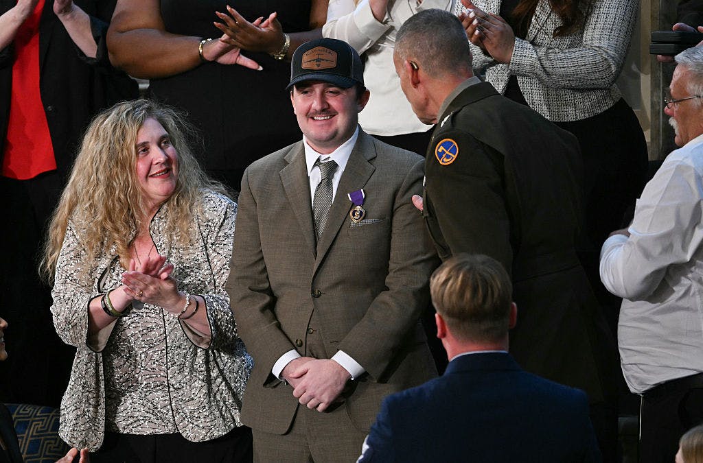 National Guard Staff Sgt. Andrew Wolfe, who survived a November 2025 shooting attack in Washington, DC, receives a Purple Heart as he is recognized by US President Donald Trump during his State of the Union address in the House Chamber of the US Capitol in Washington, DC, on February 24, 2026. 
