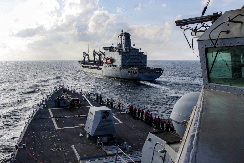 In this handout photograph released by the US Navy, the Arleigh Burke-class guided-missile destroyer USS Frank E. Petersen Jr. (DDG 121) sails alongside fleet replenishment oiler USNS Henry J. Kaiser (T-AO-187), during a replenishment-at-sea in the Arabian Sea.