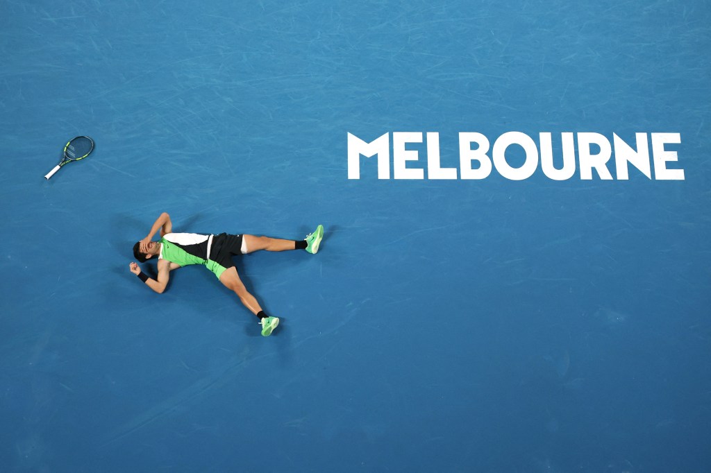 Carlos Alcaraz collapses to the court after winning the Australian Open men's final over Novak Djokovic on Feb. 1, 2026.