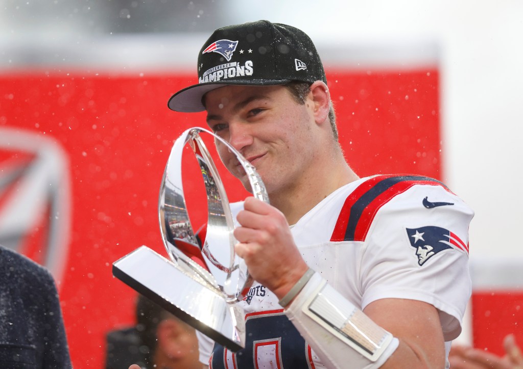 Drake Maye celebrates with the Lamar Hunt trophy after the Patriots' win over the Broncos in the AFC Championship.
