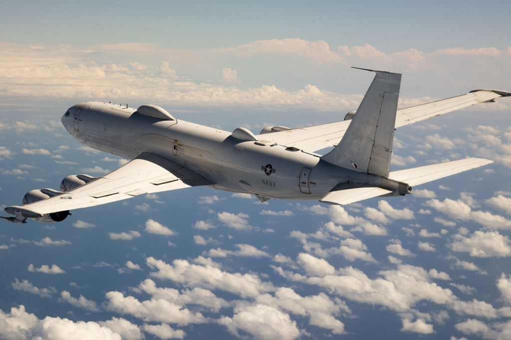 A 150-foot-long Boeing E-6B Mercury, colloquially known as the "Doomsday Plane", flying above the clouds.