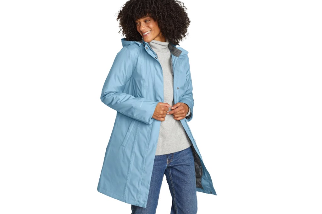 Lisa Bonet smiling and wearing a blue raincoat
