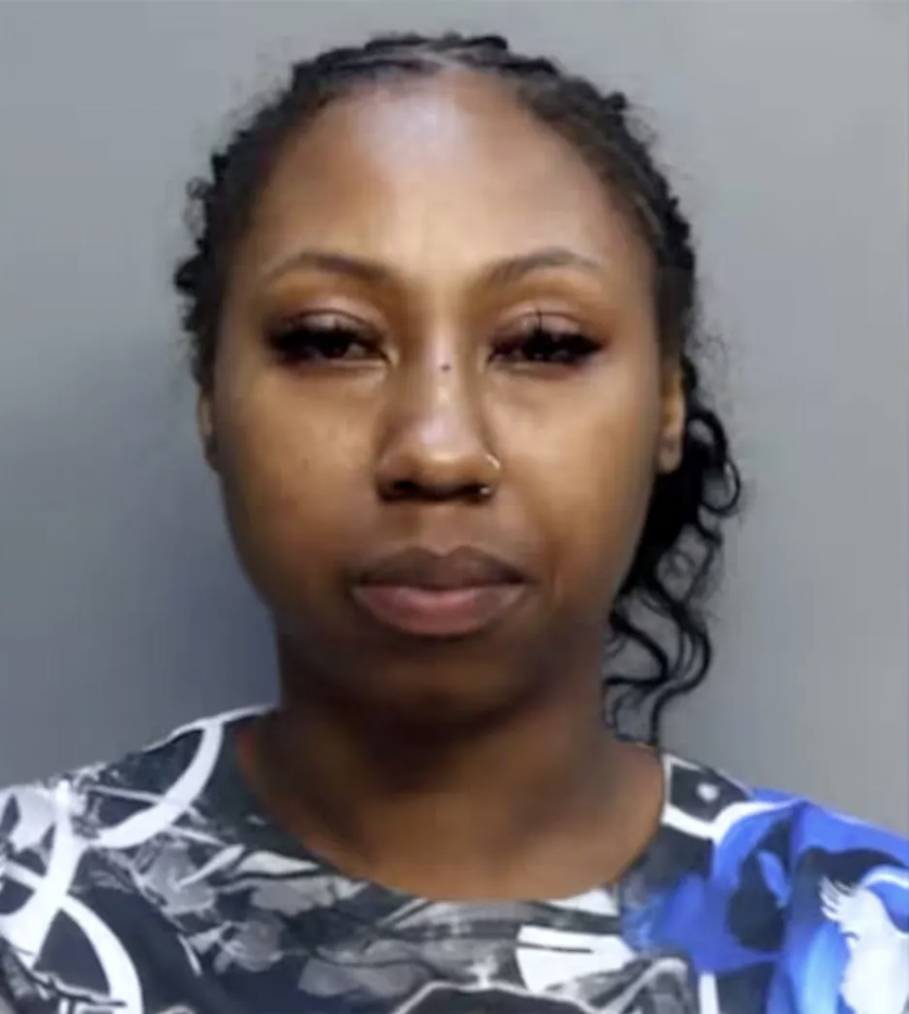 Mugshot of a woman with dark hair pulled back, wearing a patterned shirt.