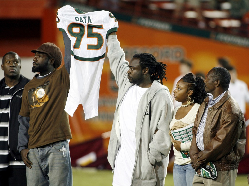 Bryan Pata's family holds up his jersey at the beginning of an NCAA college football game between Miami and Boston College.