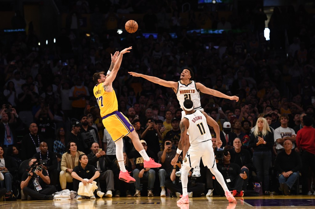 Luka Doncic (Los Angeles Lakers) shoots a game-winning shot against Nikola Jokic (Denver Nuggets) and Christian Braun (Denver Nuggets).