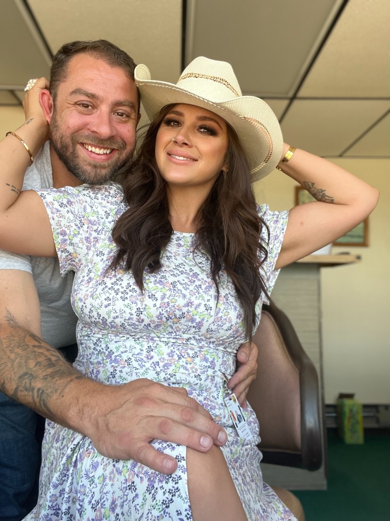 A man and a woman in a cowboy hat smiling.