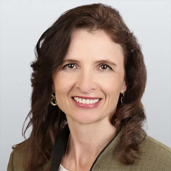 San Diego School Board Member wearing a green blazer, smiling.