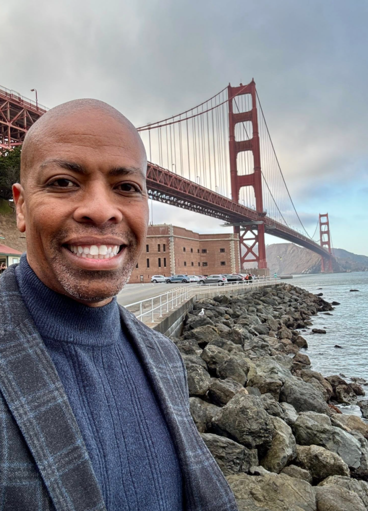 Paul Henderson smiling in front of the Golden Gate Bridge.