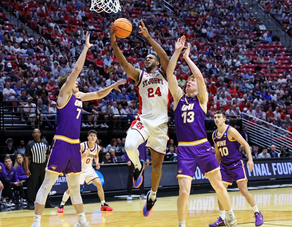 Forward Zuby Ejiofor #24 of the St. John's Red Storm goes up for a shot between forward Ben Schwieger #7 of the Northern Iowa Panthers and forward Will Hornseth #13 of the Northern Iowa Panthers during the first half.

