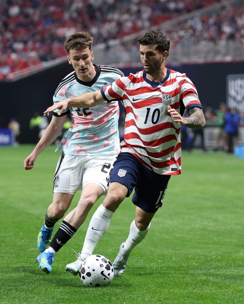 Christian Pulisic of the United States dribbling the soccer ball while Alexis Saelemaekers of Belgium defends him.