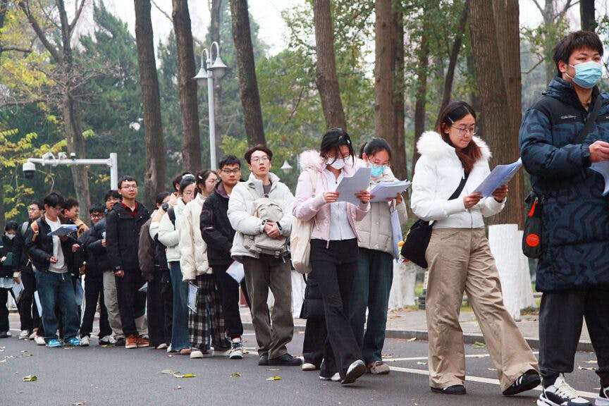 NANJING, CHINA - DECEMBER 20: Examinees review their study materials outside an examination site for the 2026 postgraduate entrance exam on December 20, 2025 in Nanjing, Jiangsu Province of China. 2026 China's national exam for postgraduate enrolment kicked off on December 20. (Photo by Liu Jianhua/VCG via Getty Images)