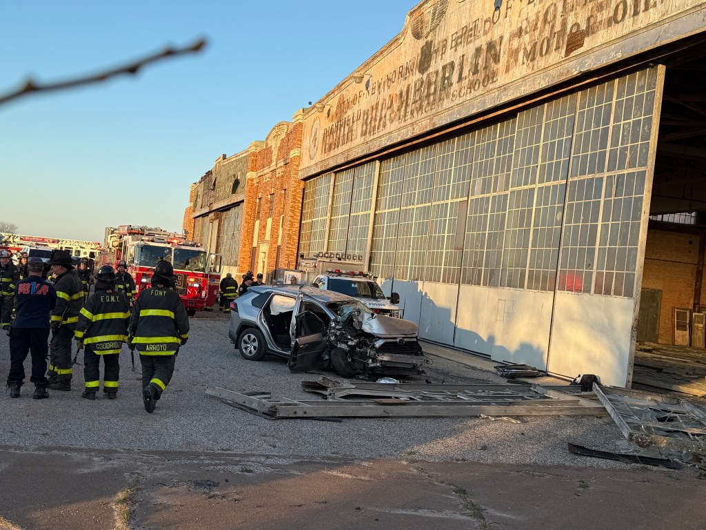 Police and firefighters at the scene of an SUV into a historic airport hanger at Floyd Bennett Field in Brooklyn.