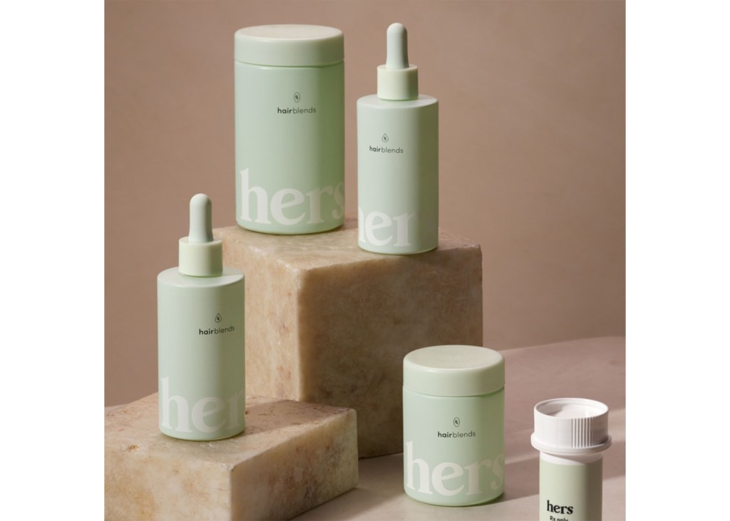 Hers hair growth products in light green containers on marble blocks.