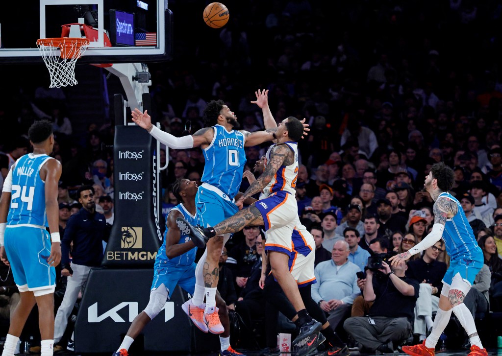 New York Knicks player Jeremy Sochan shoots the ball as Charlotte Hornets player Miles Bridges jumps to block the shot.