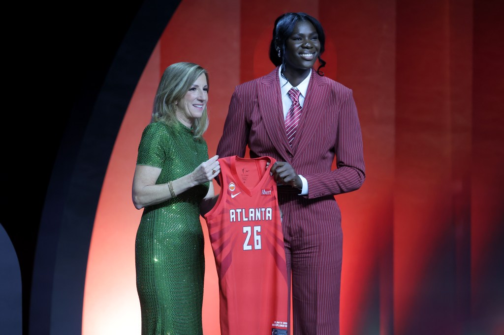 WNBA Commissioner Cathy Engelbert and Madina Okot pose with Okot's Atlanta Dream jersey.