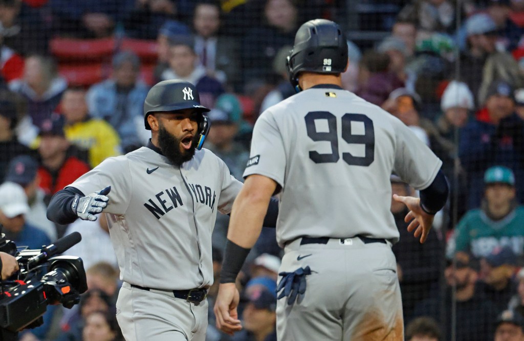  New York Yankees third baseman Amed Rosario celebrates with New York Yankees right fielder Aaron Judge (99) after they score on his three-run home run during the first inning.