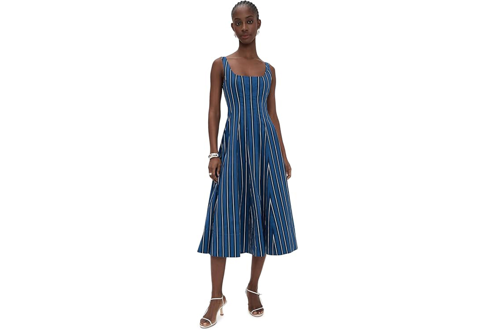 A model wearing the Staud Wells striped dress with white heeled sandals.