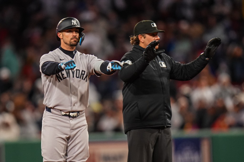 New York Yankees left fielder Randal Grichuk (34) after hitting a double, with an umpire beside him.