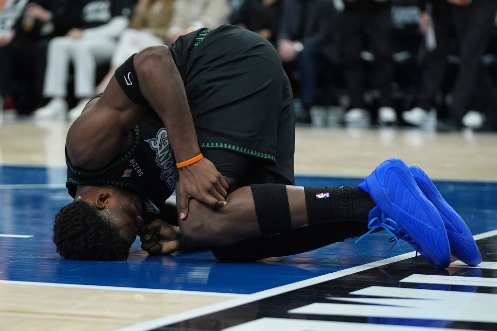 Timberwolves guard Anthony Edwards holds his knee after suffering an injury during Game 4 against the Nuggets on April 25, 2026.