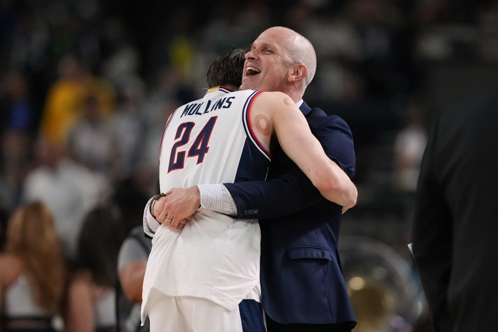 UConn head coach Dan Hurley embraces player Braylon Mullins after defeating Illinois in an NCAA tournament semifinal game.