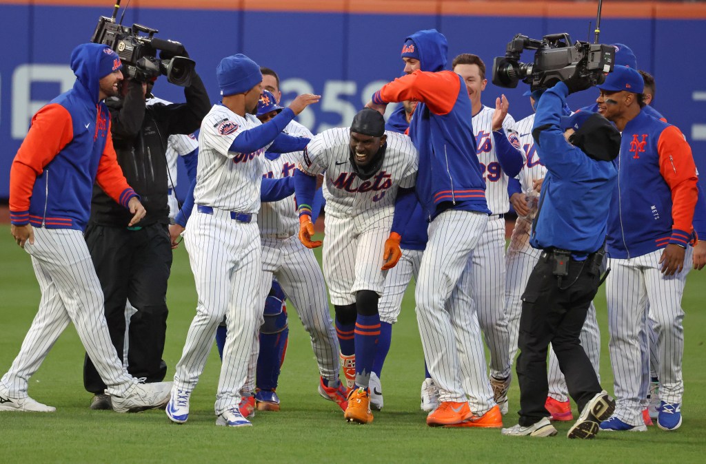Ronny Mauricio (center) is mobbed by teammates after his walk-off RBI single led the Mets to a 4-3 victory over the Diamondbacks on April 7, 2026 at a cold Citi Field.