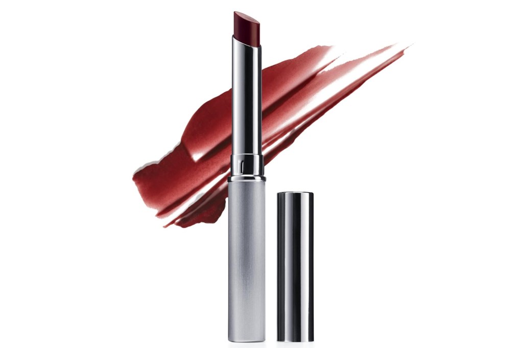 An open tube of red lipstick, with its cap next to it, and a streak of red lipstick in the background.