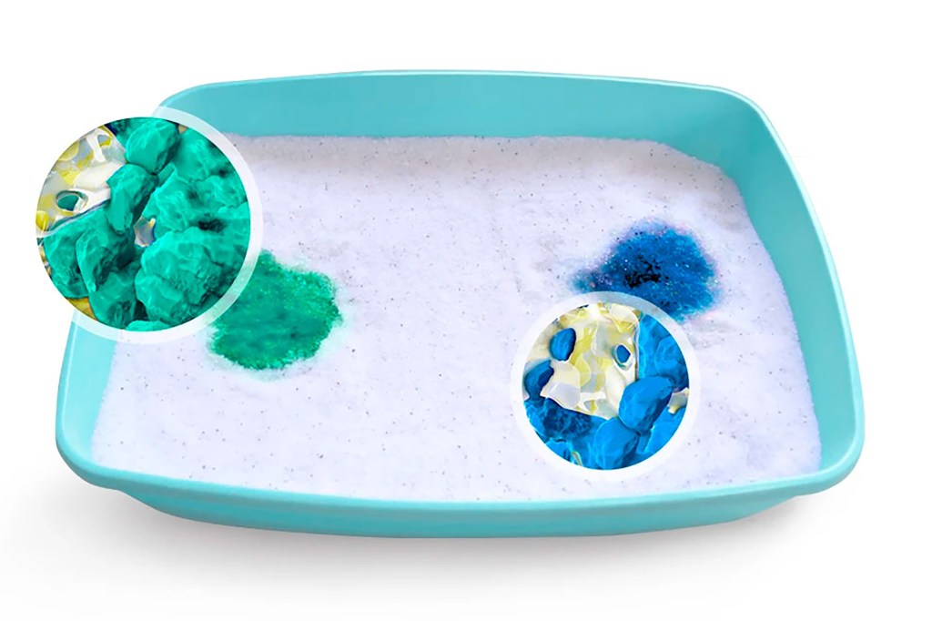A litter box with a green spot and a blue spot 
